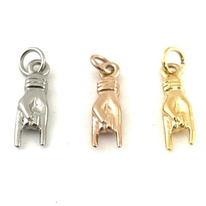 May include: Three metal charms in the shape of a hand making the rock and roll hand gesture. The charms are silver, rose gold, and gold.