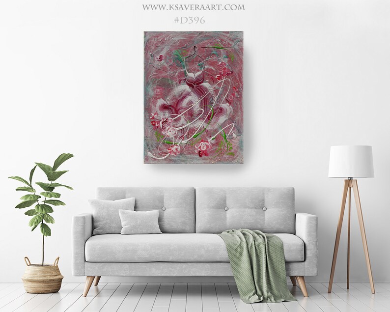 May include: Abstract painting of a pink dress with white and green floral details on a gray background. The painting is framed and hanging on a white wall above a gray couch.