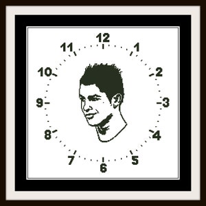 May include: A black and white clock with a portrait of a man in the center. The numbers 1 through 12 are displayed around the edge of the clock.