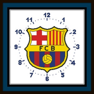 Puede incluir: Una esfera de reloj blanca con un logotipo de equipo de fútbol azul y rojo en el centro. El logotipo tiene un fondo amarillo y las letras FCB. La esfera del reloj tiene los números del 1 al 12 alrededor del borde.
