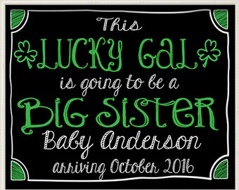 May include: Black and green chalkboard sign with white text that reads "This LUCKY GAL is going to be a BIG SISTER Baby Anderson arriving October 2016".