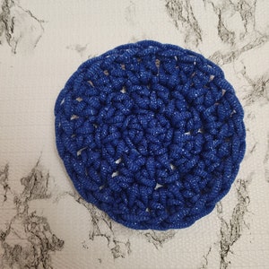 May include: A blue crocheted round coaster with a sparkly finish.