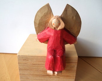 Wooden angel in a red dress, sitting, 13 cm