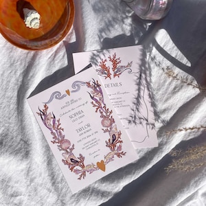 May include: A pink and white wedding invitation with a seashell and coral design. The invitation reads "You are joyfully invited to celebrate the wedding of Sophia Lilly Zayan and Taylor Ann Roman, June 17th, 2024 at 3PM, Lowndes Grove, 266 Saint Margaret St, Charleston, SC."