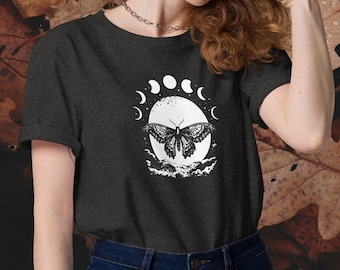 May include: A dark grey t-shirt with a white graphic of a butterfly flying in front of a moon with crescent moons around it.
