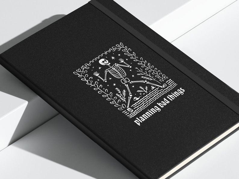 May include: Black notebook with a white skeleton illustration and the text "planning bad things".