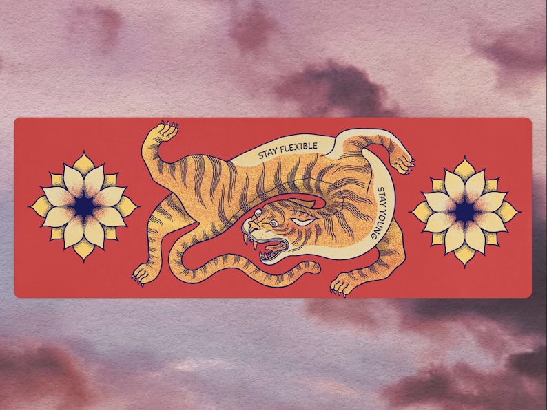 May include: A red background with a stylized orange tiger illustration. The tiger is curled up with the text "STAY FLEXIBLE" and "STAY YOUNG" written on its body. Two yellow flowers with blue centers are on either side of the tiger.