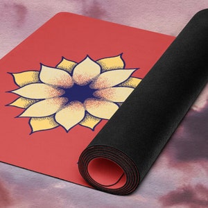 May include: A red yoga mat with a yellow and blue flower design. The mat is rolled up and the end is visible.