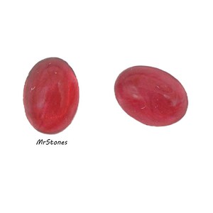 May include: Two oval-shaped, red gemstones. The gemstones have a smooth, polished surface and a translucent appearance. The text "MrStones" is visible at the bottom left.