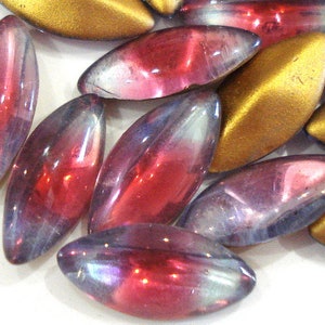 May include: Assortment of iridescent glass beads in shades of red, purple, and gold. The beads are oval shaped and have a smooth, glossy finish.