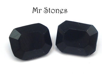 May include: Two black octagon-shaped gemstones. The gemstones are faceted and have a glossy finish.