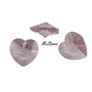 May include: Three crystal beads in a light pink color. Two are heart shaped and one is a square shape.