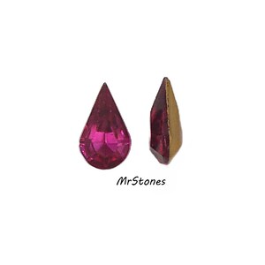 May include: Two teardrop-shaped, faceted, fuchsia-colored gemstones. One stone is viewed from the front, the other from the side, revealing a gold-colored backing. The text "MrStones" is printed below the gemstones.
