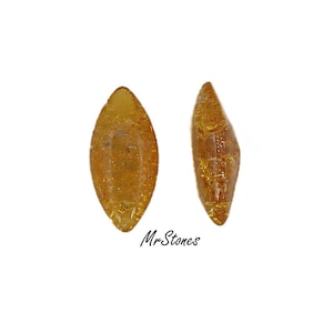 May include: Two amber-colored, teardrop-shaped stones with a textured surface. The stones have a glittery appearance and are set against a white background. The text "Mr Stones" is visible.