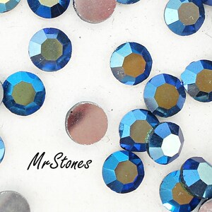 Puede incluir: Surtido de pedrería azul iridiscente, algunas con un tono dorado, esparcidas sobre una superficie blanca.  Mr. Stones.