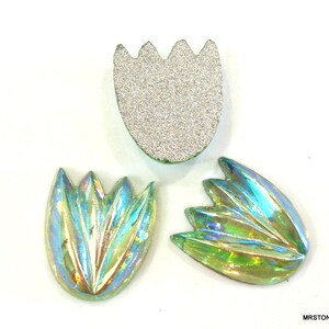 May include: Three iridescent green glass tulip-shaped embellishments. The embellishments have a raised, textured design.