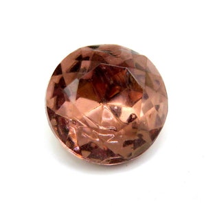 May include: A large, faceted, brown glass button with a shiny, reflective surface.