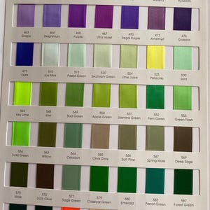 May include: A colour chart showing satin ribbons in various shades, including purple, green, yellow, and orange. Each ribbon is labelled with a colour name and number, such as "Lilac Mist" and "Key Lime".