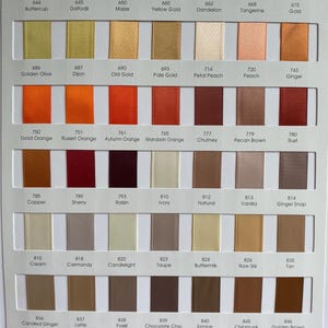 May include: Colour chart displaying ribbon swatches in a range of hues, including yellow, orange, brown, and neutral shades. Each colour is labelled with a name and number, providing a diverse palette for craft and design work.