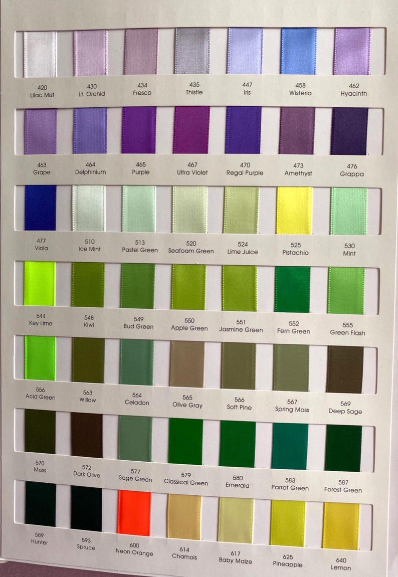 May include: A colour chart showing a selection of satin ribbon swatches. The chart presents a spectrum of colours, including purples, greens, and yellows, with each colour labelled with a number and name. The ribbons are arranged in neat rows.