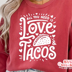 May include: Red sweatshirt with white text that reads "All you need is love & tacos" with a taco graphic. The text is in a fun, handwritten font.