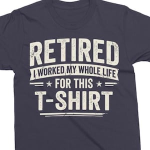 Könnte beinhalten: Marineblaues T-Shirt mit dem weißen Text "RETIRED I WORKED MY WHOLE LIFE FOR THIS T-SHIRT". Der Text ist in einer Used-Schriftart gehalten. Das Shirt hat einen Rundhalsausschnitt und kurze Ärmel.