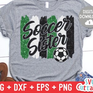 May include: A gray t-shirt with a green, white, and black glitter design that says "Soccer Sister" with a soccer ball in the center.