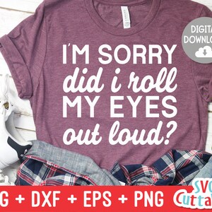 Puede incluir: Camiseta granate con el texto blanco "I'M SORRY did i roll MY EYES out loud?". La camiseta está doblada con unos vaqueros y una camisa a cuadros. Un icono de descarga digital está en la esquina superior derecha.