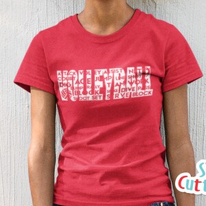 May include: Red t-shirt with white text that reads "VOLLEYBALL" with other volleyball terms surrounding the word. The text is in a block style font.
