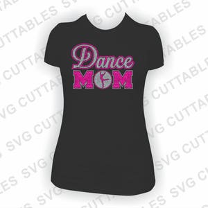 Puede incluir: Camiseta negra con texto en purpurina rosa que dice "Dance Mom" con una silueta rosa de una bailarina en el medio de la palabra "Mom".