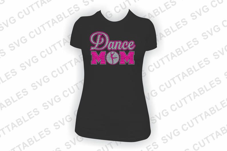 Puede incluir: Camiseta negra con texto en purpurina rosa que dice "Dance Mom" con una silueta rosa de una bailarina en el medio de la palabra "Mom".