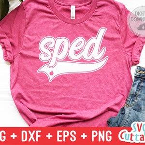 May include: A pink t-shirt with the word "sped" in white text with a white baseball-style arc underneath. The arc has a small red apple icon inside it.