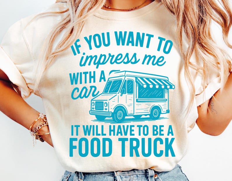 May include: Cream-colored t-shirt with the text "IF YOU WANT TO impress me WITH A car IT WILL HAVE TO BE A FOOD TRUCK" in turquoise. The graphic includes a food truck illustration.