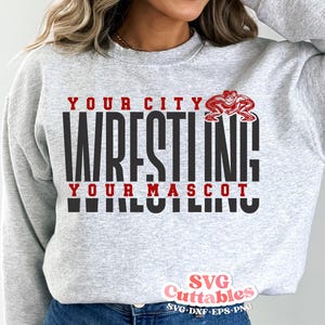 May include: Gray sweatshirt with the text "YOUR CITY WRESTLING YOUR MASCOT WRESTLING" in black and red. A red frog graphic is above the text.