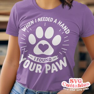 May include: Purple t-shirt with a white paw print design and the text "When I needed a hand I found your paw".
