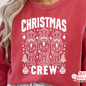 May include: Red sweatshirt with a white design featuring three nutcracker figures and the text "Christmas Crew".
