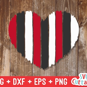 May include: A red, white, and black striped heart shape with a distressed, brushstroke effect. The heart is on a wood background.