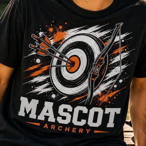 May include: Black t-shirt featuring a graphic of a target with arrows, a bow, and the words "MASCOT ARCHERY" in white block letters with orange accents. The design includes orange and white paint splatters. Archery-themed apparel.