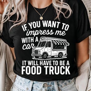 May include: Black t-shirt with the text "IF YOU WANT TO impress me WITH A car IT WILL HAVE TO BE A FOOD TRUCK" in white. The graphic includes a food truck illustration.