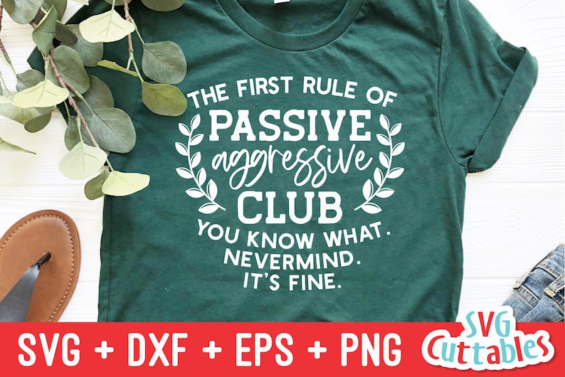 May include: A green t-shirt with white text that reads "The First Rule of Passive Aggressive Club You Know What. Nevermind. It's Fine."