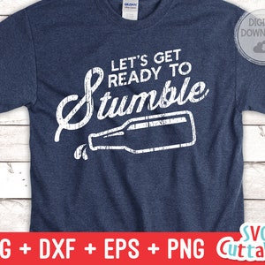 May include: A blue t-shirt with white text that reads "Let's get ready to stumble" with a white silhouette of a beer bottle pouring out a drink.