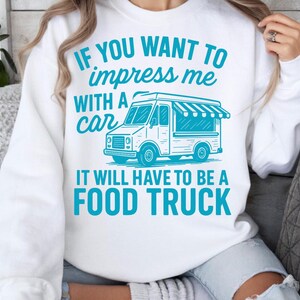May include: White sweatshirt with a teal graphic of a food truck and the text: "IF YOU WANT TO impress me WITH A car IT WILL HAVE TO BE A FOOD TRUCK."