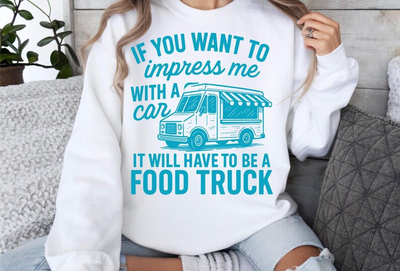 May include: White sweatshirt with a teal graphic of a food truck and the text: "IF YOU WANT TO impress me WITH A car IT WILL HAVE TO BE A FOOD TRUCK."