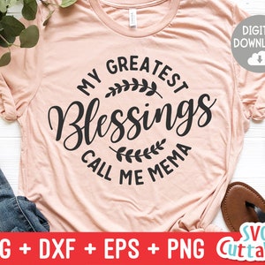 May include: A pink t-shirt with the text "My Greatest Blessings Call Me Mema" in black lettering with a floral design.