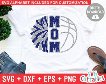 May include: A white t-shirt with a blue and silver glitter design that says "MOM". The design includes a cheerleading pom-pom and a basketball.