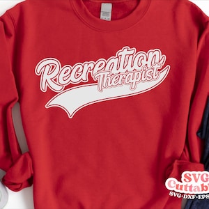 May include: Red sweatshirt with white text that reads "Recreation Therapist" in a baseball-style font.