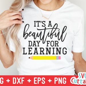 Könnte beinhalten: Weißes T-Shirt mit schwarzem Text, der "Es ist ein wunderschöner Tag zum Lernen" lautet, und einem gelben Bleistift mit rosa Radiergummi.