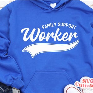 May include: Royal blue hooded sweatshirt with white text that reads "Family Support Worker" in a vintage baseball jersey style font. The text is outlined in white and has a white curved line underneath.