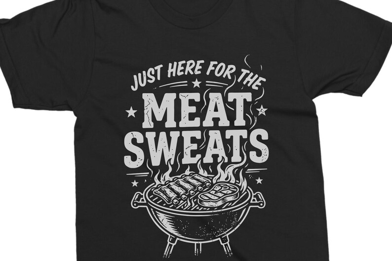 May include: Black t-shirt with a white graphic. The graphic features the text "JUST HERE FOR THE MEAT SWEATS" above an illustration of a barbecue grill with ribs and a steak. Stars and flames are also included in the design.
