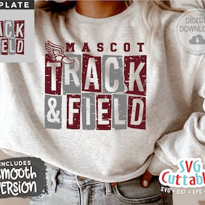 Puede incluir: Una sudadera gris con un diseño granate que dice "MASCOT TRACK & FIELD" con un gráfico de pie alado granate. El diseño tiene un aspecto desgastado. El texto "TEMPLATE" está en la esquina superior izquierda y "DIGITAL DOWNLOAD" está en la esquina superior derecha. El texto "INCLUDES Smooth VERSION" está en la esquina inferior izquierda y "SVG Cuttables SVG + DXF + EPS + PNG" está en la esquina inferior derecha.